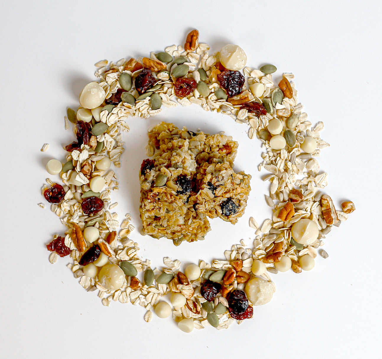 Griff-n-Grizzly white chocolate cranberry macadamia granola bites surrounded by a circle of ingredients